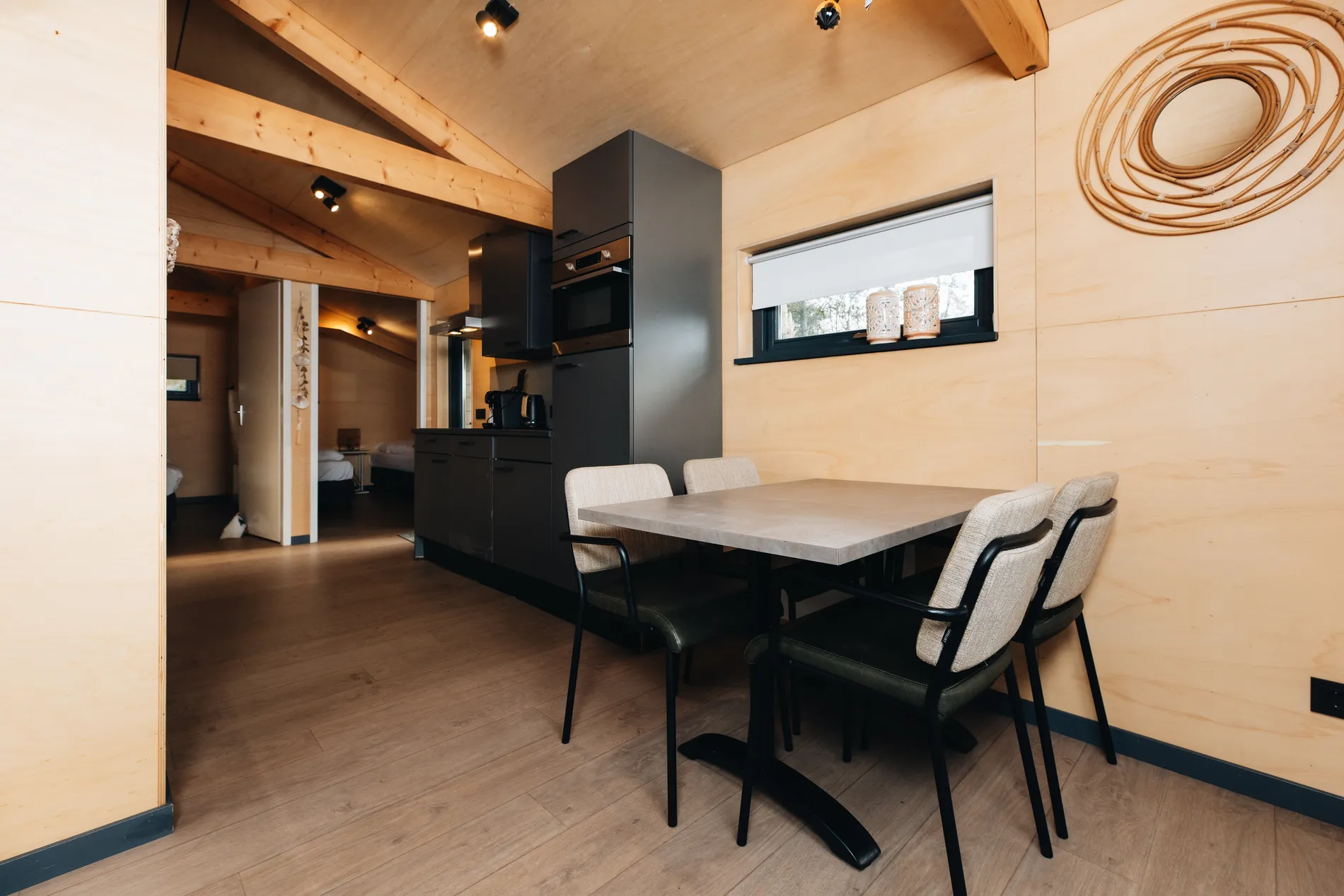 Eigentijdse eethoek in de Ecolodge bij Resort Land & Zee tegen een houten achtergrond.